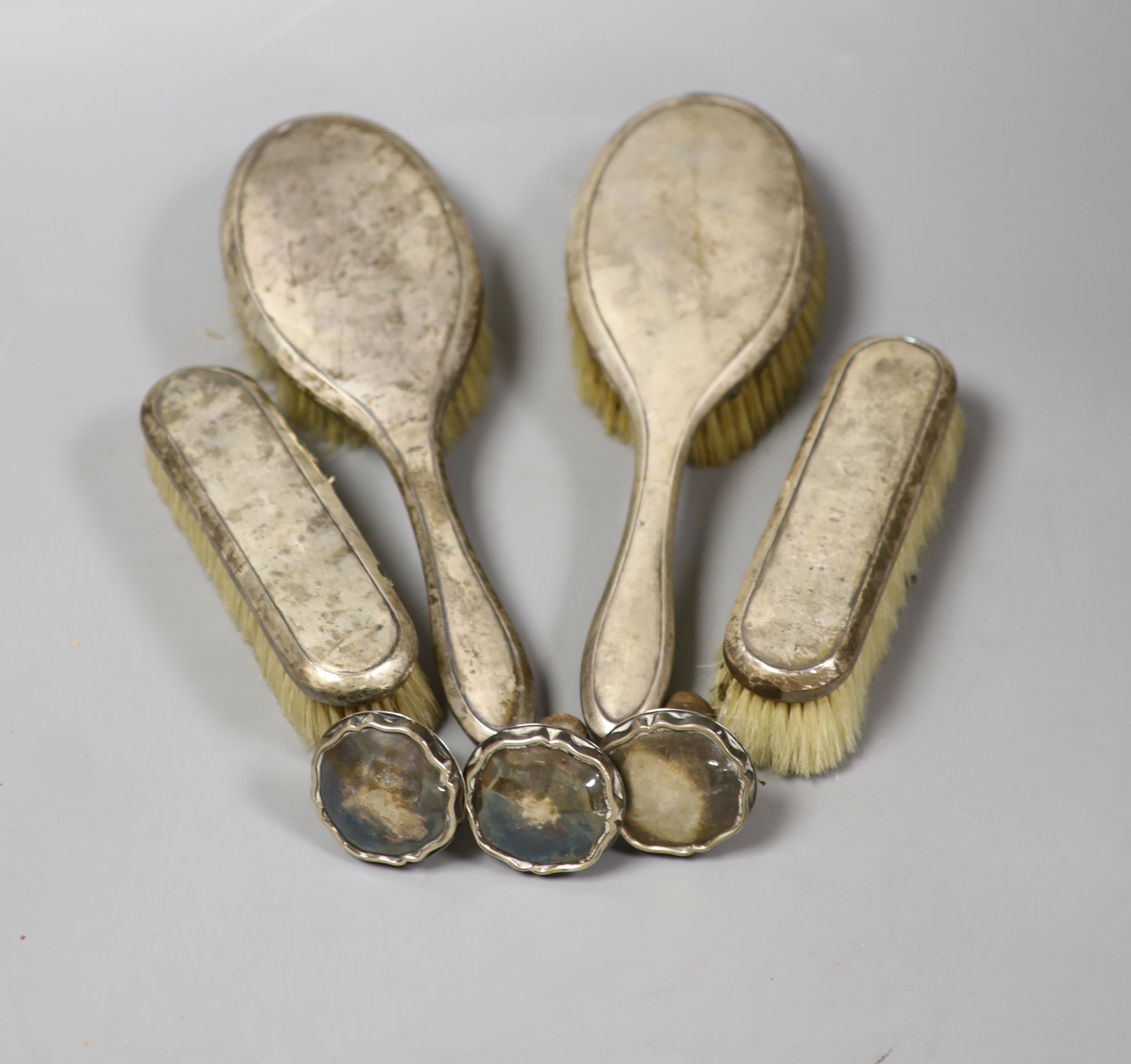 Four silver mounted brushes and three 830s mounted stoppers.